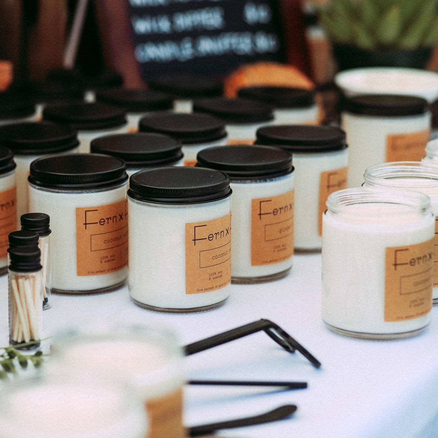 Fern x Flow Signature soy Candle Collection table display at a local farmer's market in Boston..