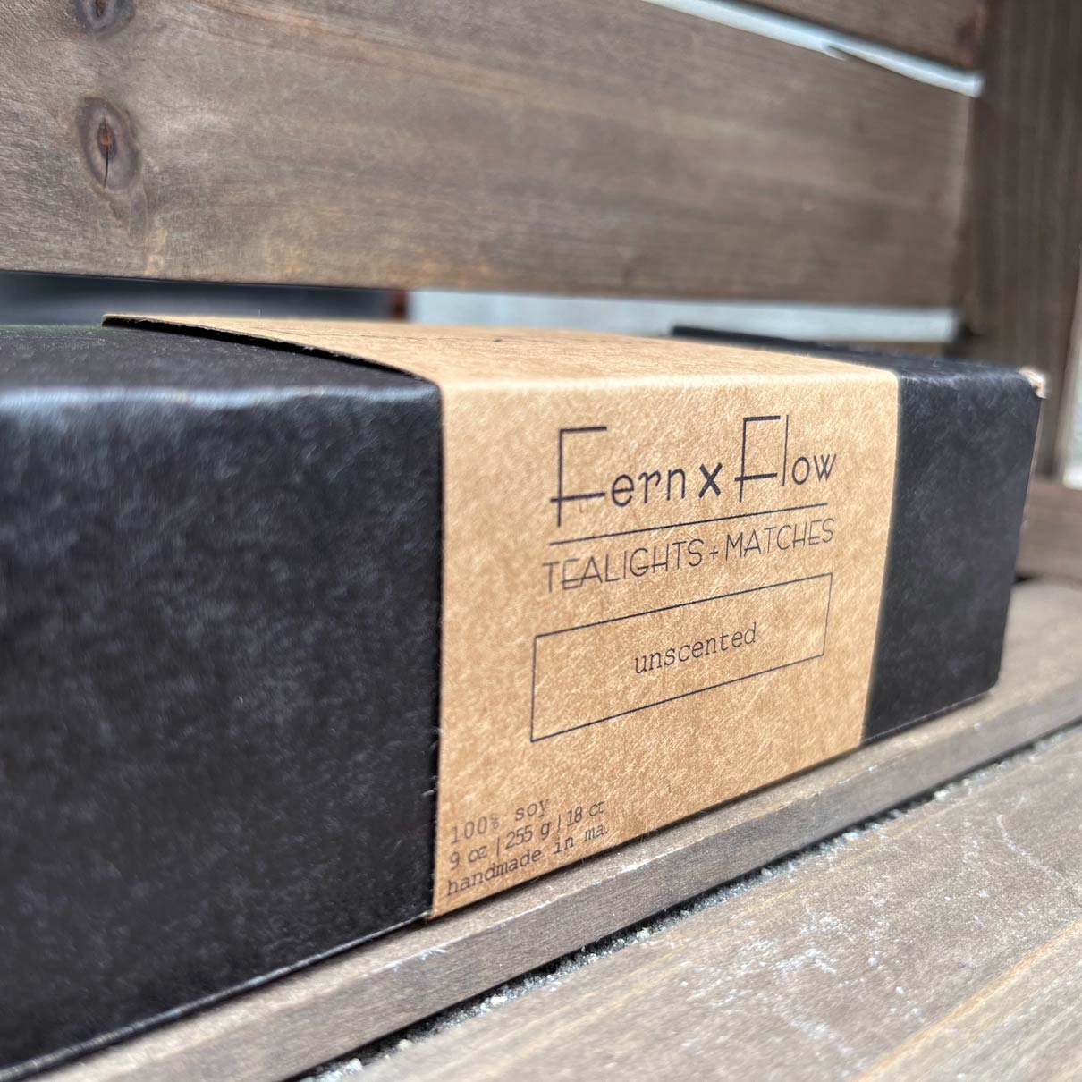Fern x Flow soy candle company soy tealight candle package in black matte box with a kraft-brown paper sleeve.