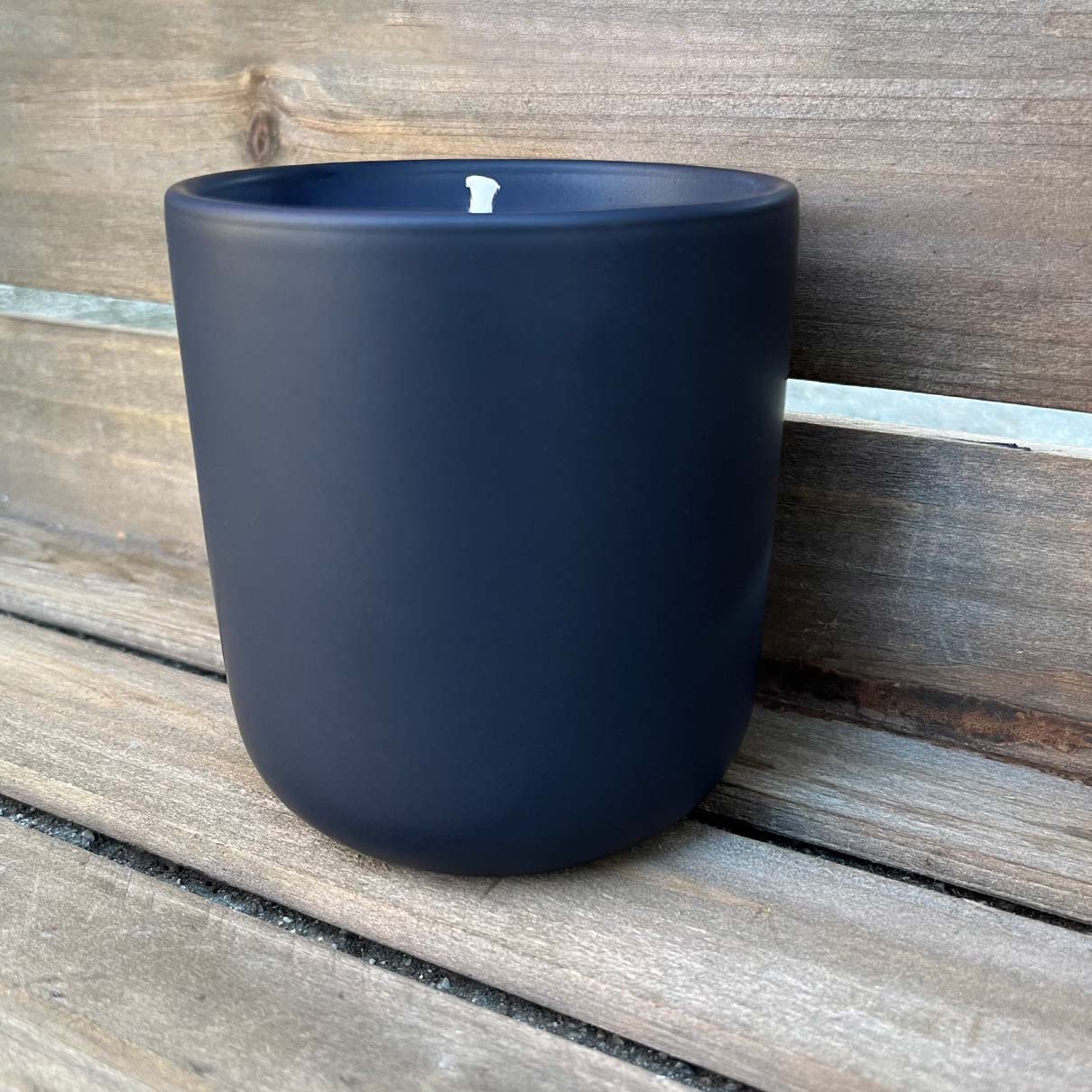 
                  
                    Fern x Flow 10oz hand-poured, 100% soy candle in a modern, matte black ceramic tumbler against a weathered wooden background.
                  
                