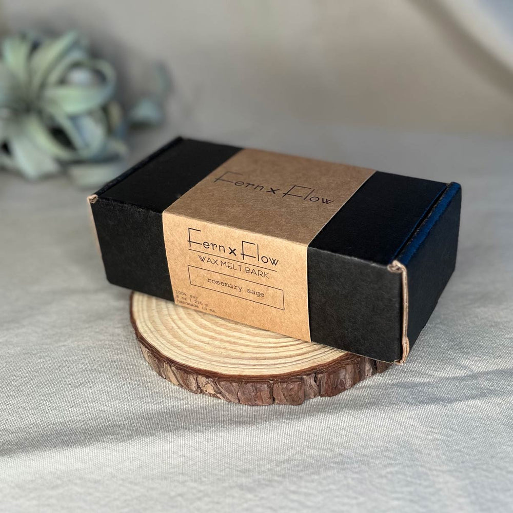 
                  
                    Eight-ounce box of Fern x Flow hand-poured wax melt bark on a rustic wooden risen with a large air plant in the background.
                  
                