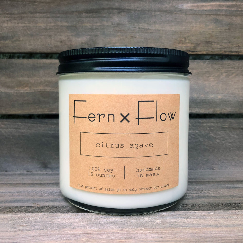 Sixteen-ounce Fern x Flow Citrus Agave scented soy candle against a weathered, wooden crate.