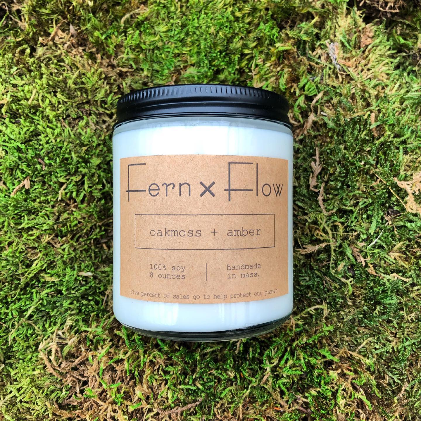 
                  
                    Eight-ounce Fern x Flow Oakmoss + Amber scented soy candle on top of lush, green moss.
                  
                